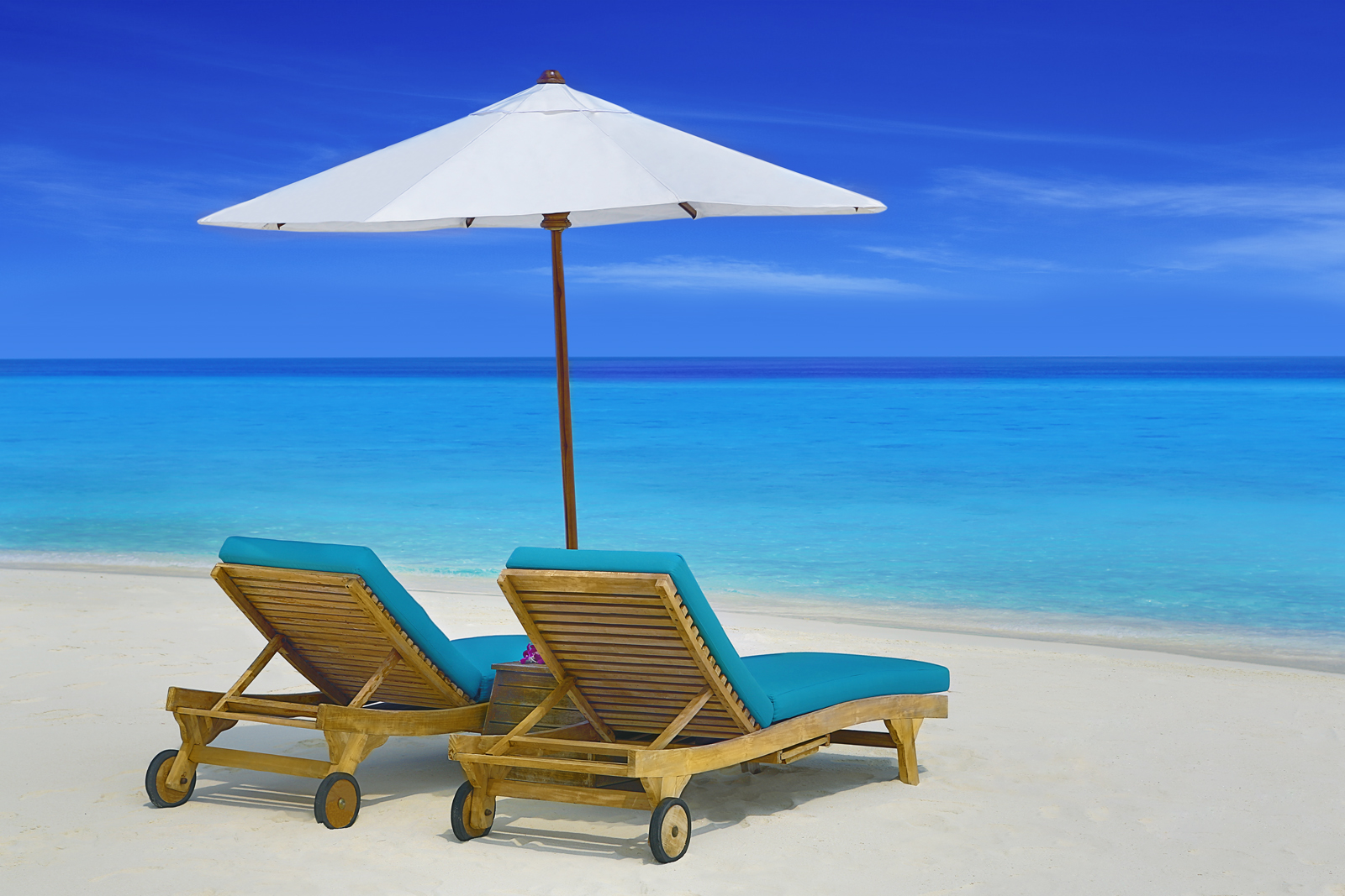 希腊克里特岛海滩海边日光浴床上的情侣高清摄影大图-千库网